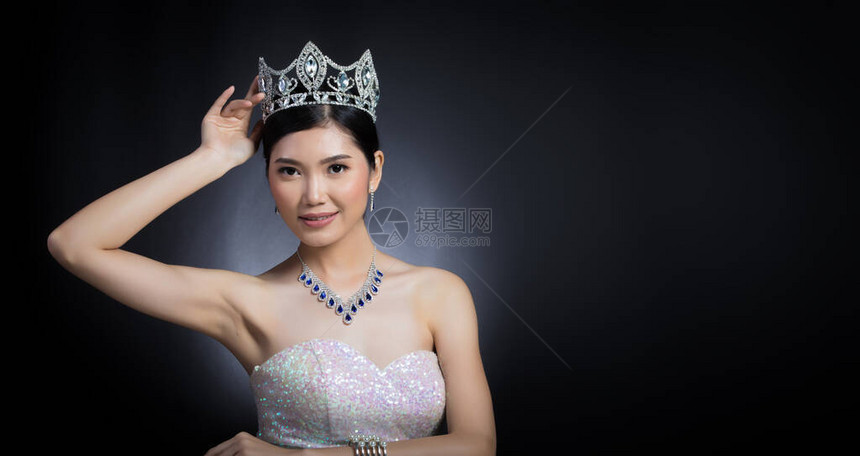 选美小姐选美大赛的肖像在亮片晚礼服长裙与闪发光的钻石皇冠图片