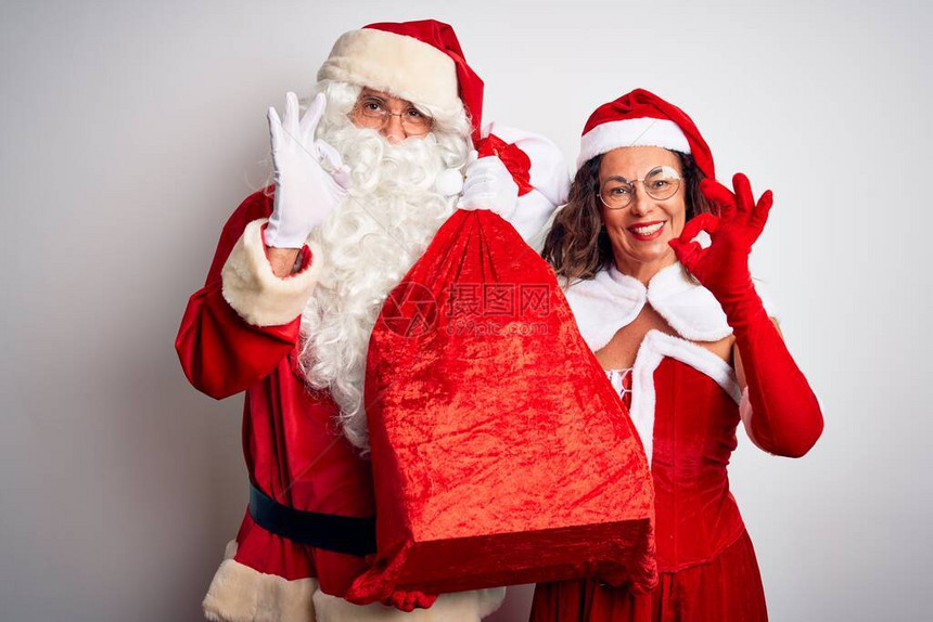 一对身穿圣诞老人服装的老夫妇在孤立的白色背景上拿着麻袋图片