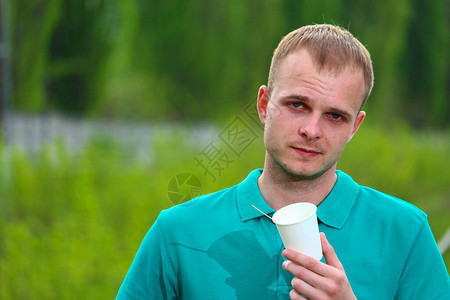身穿Marrs绿色T恤的义工手上握着一个环保型纸杯图片