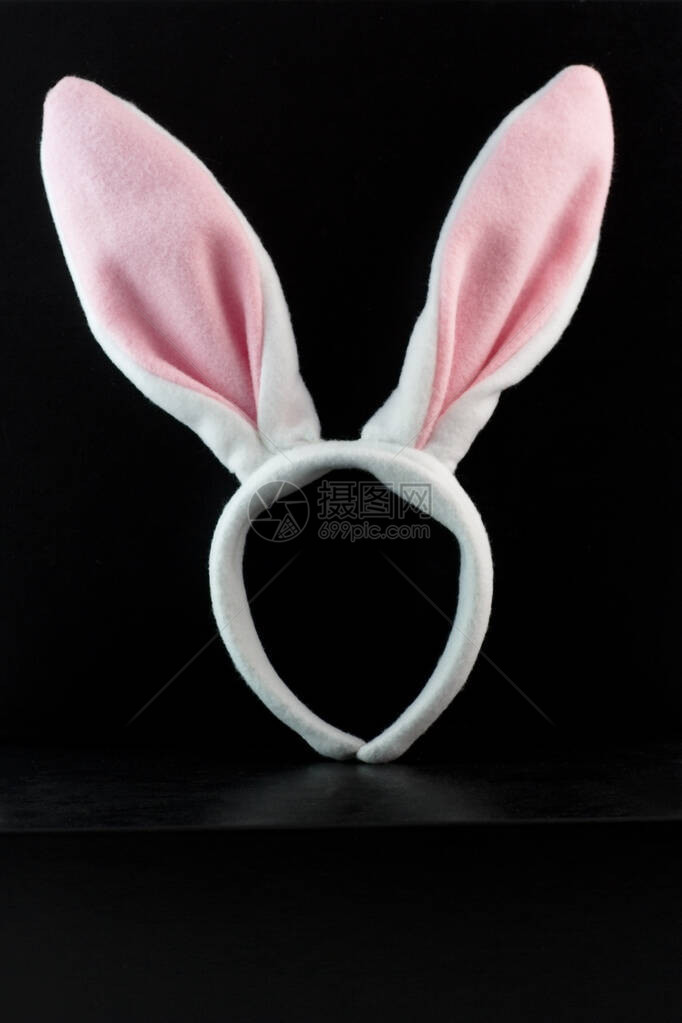 穿黑色背景的粉红色和白色复活节装扮兔图片