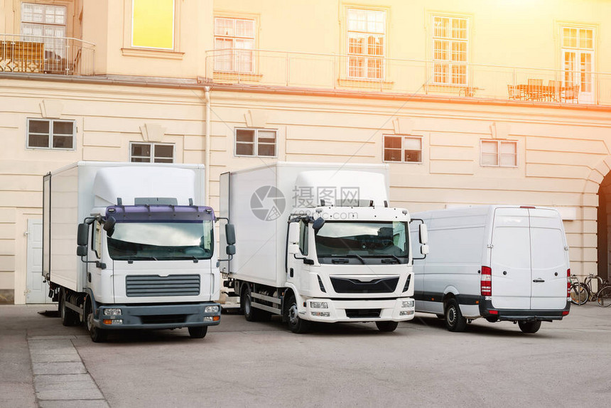 不同的中小型快递服务卡车和货车在建筑庭院城市送货运公司图片