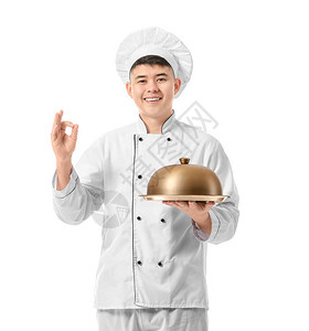 亚洲帅美厨师托盘在白背景上图片