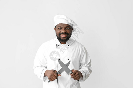白色背景上拿着刀的非洲裔美国男厨师背景图片