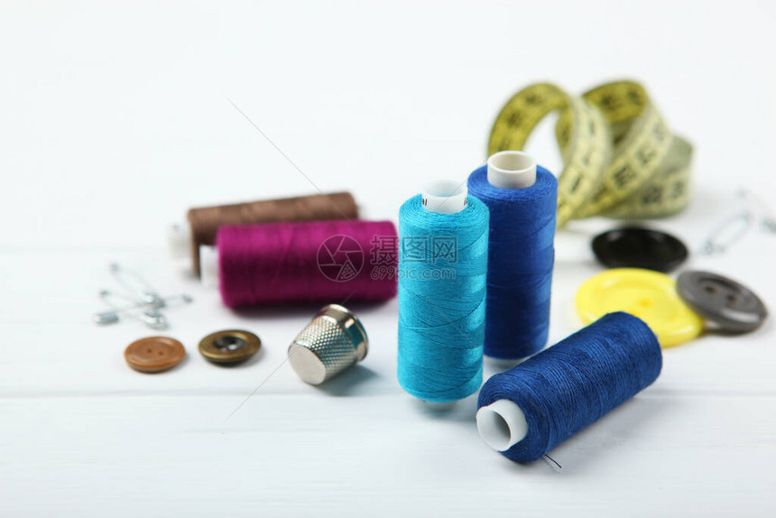 桌子上的不同缝纫配件线针织物和图片