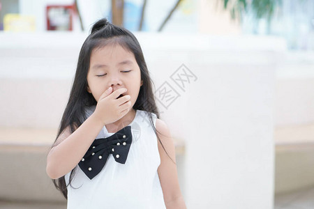 亚洲儿童可爱或小女孩站着或坐着打哈欠图片