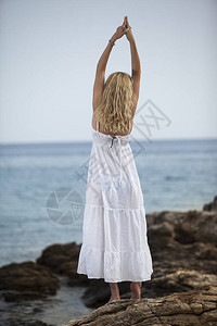 在沙滩上练习瑜伽放松的女人图片