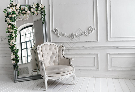白色皮椅有人造花的大镜子图片