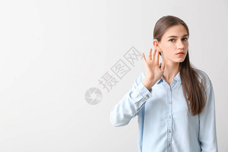 浅色背景下戴助听器的年轻女背景图片
