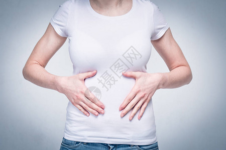 身穿白色T恤的女童因食物贫乏和营养不良而胃部和胃部疼痛图片