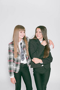 两个可爱的女学生穿着白色背景的时髦校服学校时尚儿童图片