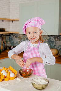 戴厨师帽和围裙的女孩揉面团图片