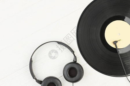 白色背景上的耳机和黑胶唱片乙烯基圆盘耳机和复制空间过时和现背景图片
