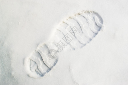 新鲜清脆的白雪中对角线构图中的单个人类脚印背景图片