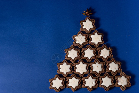 2020年新替代圣诞树自制饼干圣诞树装饰球躺在蓝色上特写图片