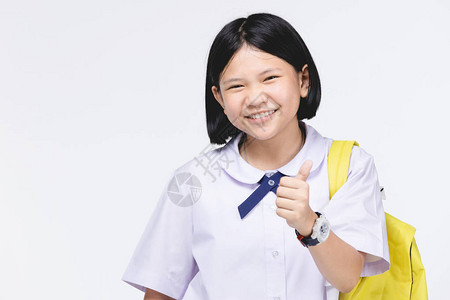 穿着学生制服的亚洲可爱女孩的肖像和灰色背景的文具图片