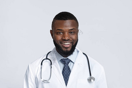 带着白色背景的听诊器的非洲男医生的图片