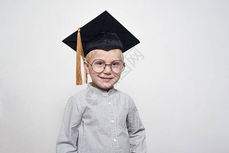 一个穿着大眼镜和学术帽子的金发美女男孩的肖图片