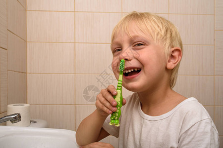 金发男孩手拿着牙刷卫生图片