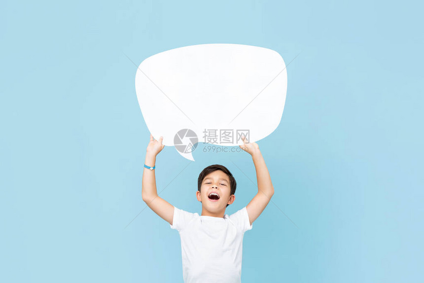 举起微笑的亚裔男孩在淡蓝色工作室背景中握着空白言图片