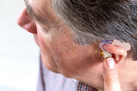 戴助听器的老人的耳朵背景图片