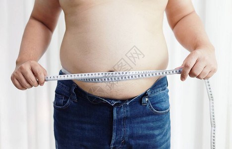 节食概念中腹部肥胖的男人超重的男人摸着他的图片