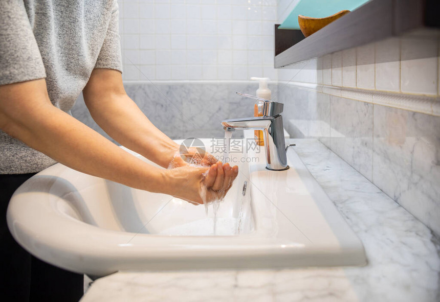 女人在浴室水槽上用肥皂和水洗手的特写镜头图片