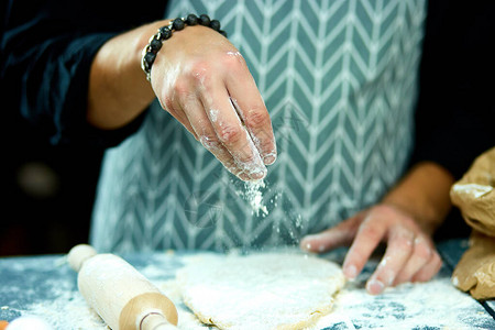 厨师将撒上面粉的面团烹饪成意大利面比萨饼面包和面包卷图片