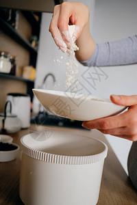 真正的女人双手在碗里撒面粉在厨房做饭时握着一整盘的手背景图片