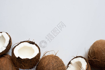 白色背景上新鲜美味的全椰子和半个椰子的顶部视图图片