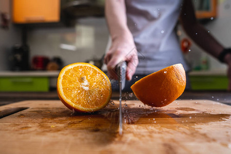 大厨用一把大刀将橙子切成两半图片