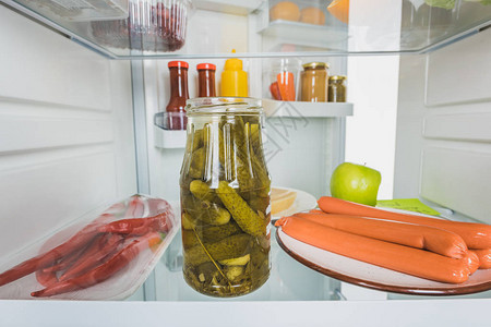 焦咸菜辣椒和香肠及酱汁在冰箱里开着图片