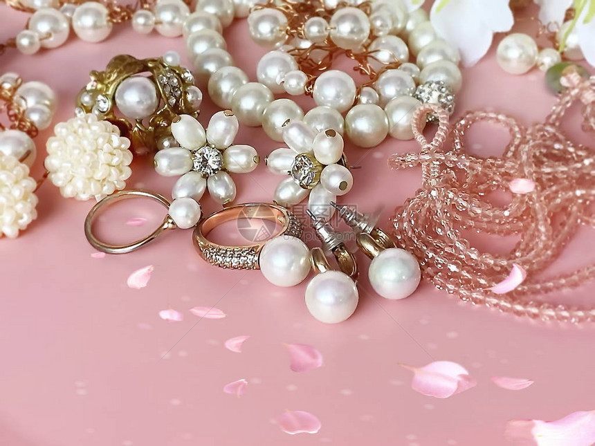 粉色背景的珠宝金白珍珠戒指耳环手镯图片