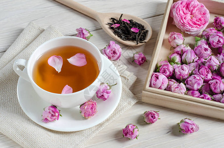 一杯茶玫瑰花和木勺子背景图片