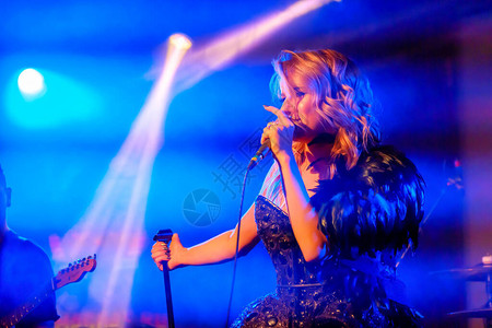 女孩歌手在夜总会的舞台上歌唱背景图片