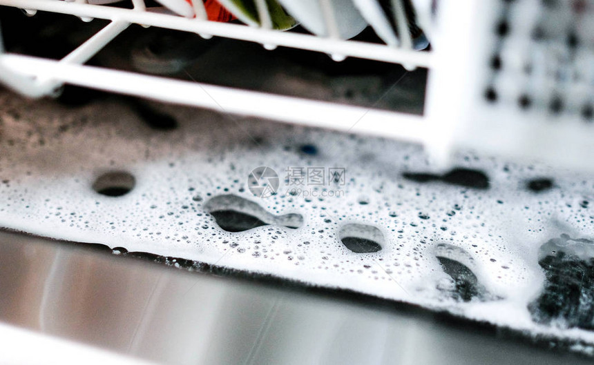 冲洗后的洗碗机在多余泡沫的底部图片