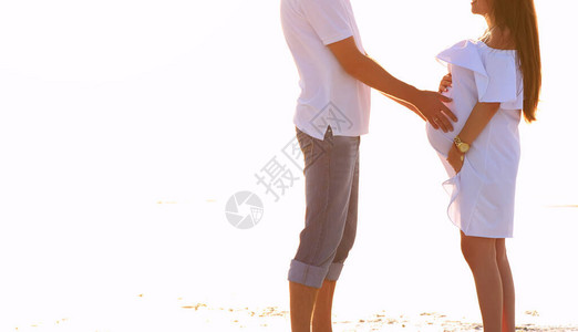 男人轻地抱着一个怀孕女孩的肚子图片