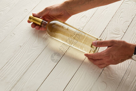 白色木制表面白葡萄酒瓶子男图片