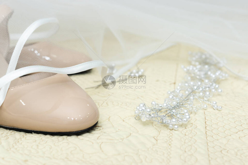 白色新娘面纱下的婚鞋和珠宝装饰图片