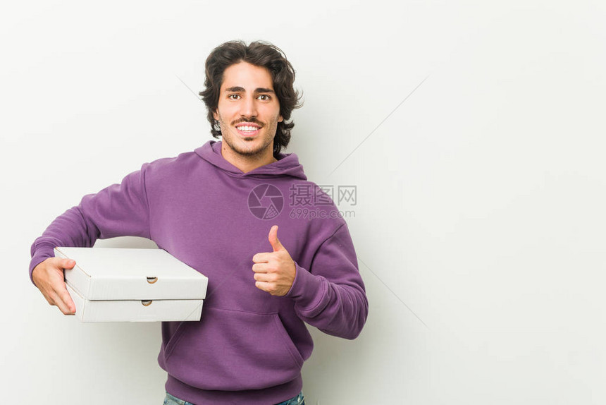 年轻男子拿着披萨包微图片