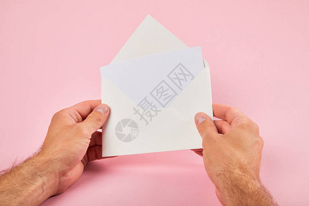 男人拿着信封粉色背景上有空白卡的剪影背景图片