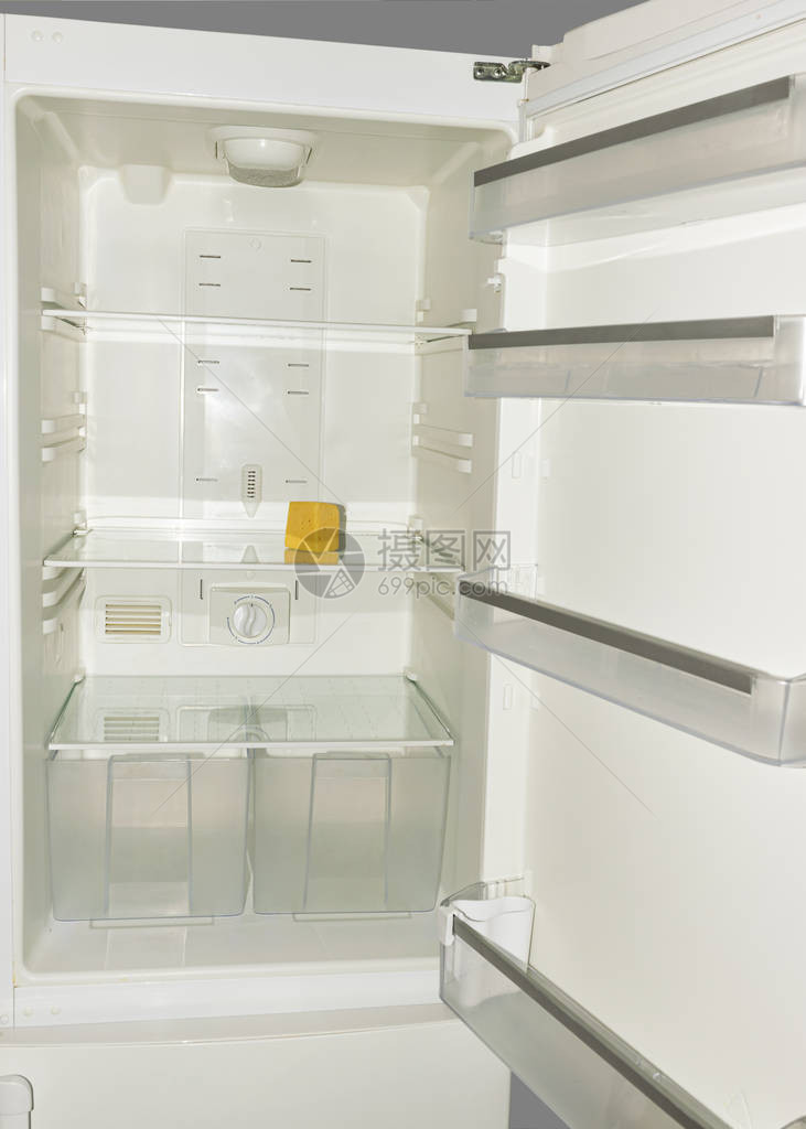 一块黄色的旧奶酪躺在冰箱的空架子上饮食和饥饿的概念适图片