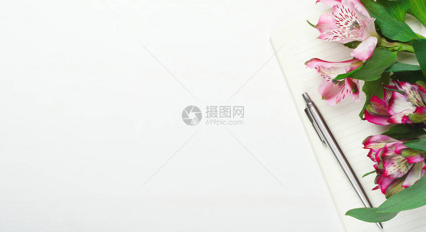 用钢笔在白木背景上贴有鲜花的铁笔作记最小成分家庭妇女办公室复制空间顶图片