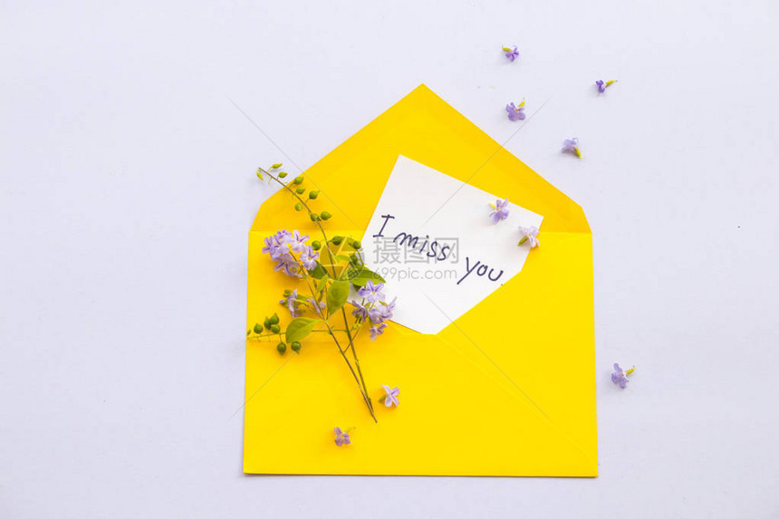 我想念你的留言卡笔迹和紫花安排在黄色信封上图片