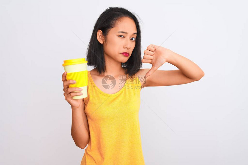 喝着咖啡的年轻女子在孤立的白色背景上拿走一杯咖啡面脸发怒图片