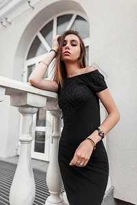 欧洲感苗条的年轻女子穿着优雅的黑色连衣裙图片