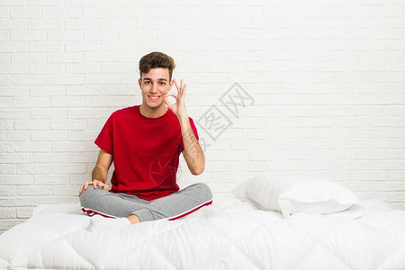 在床上的年轻少年学生男子欢乐和自信图片