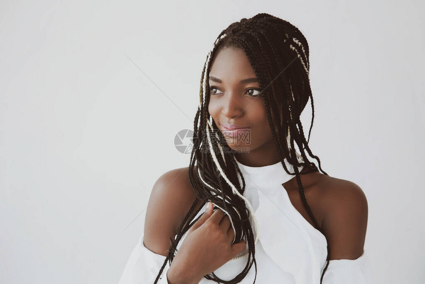 来自尼日利亚的一位美丽微笑留着辫子的黑人妇女的肖像在白色背景图片
