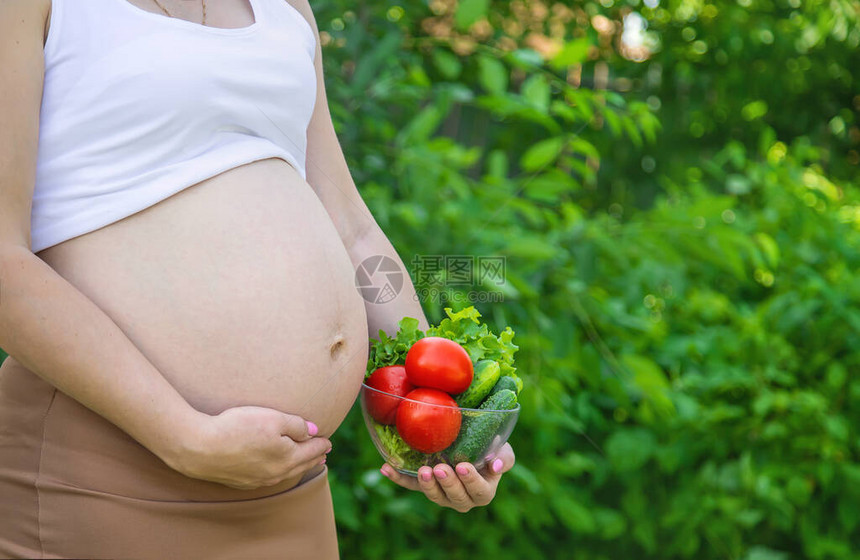 孕妇手里拿着蔬菜有选择