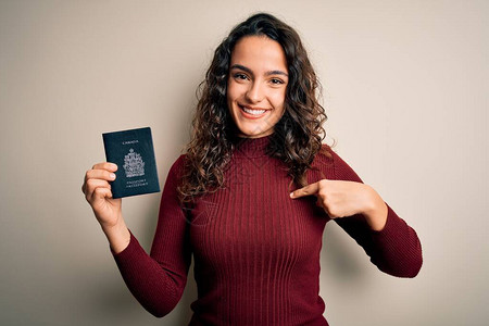 度假时卷发的年轻美女游客拿着加拿大加拿大护照图片