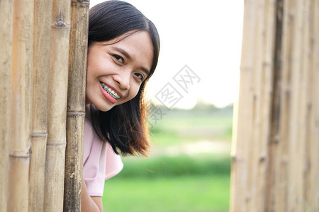 亚洲女人从竹墙上探出脸惊喜图片